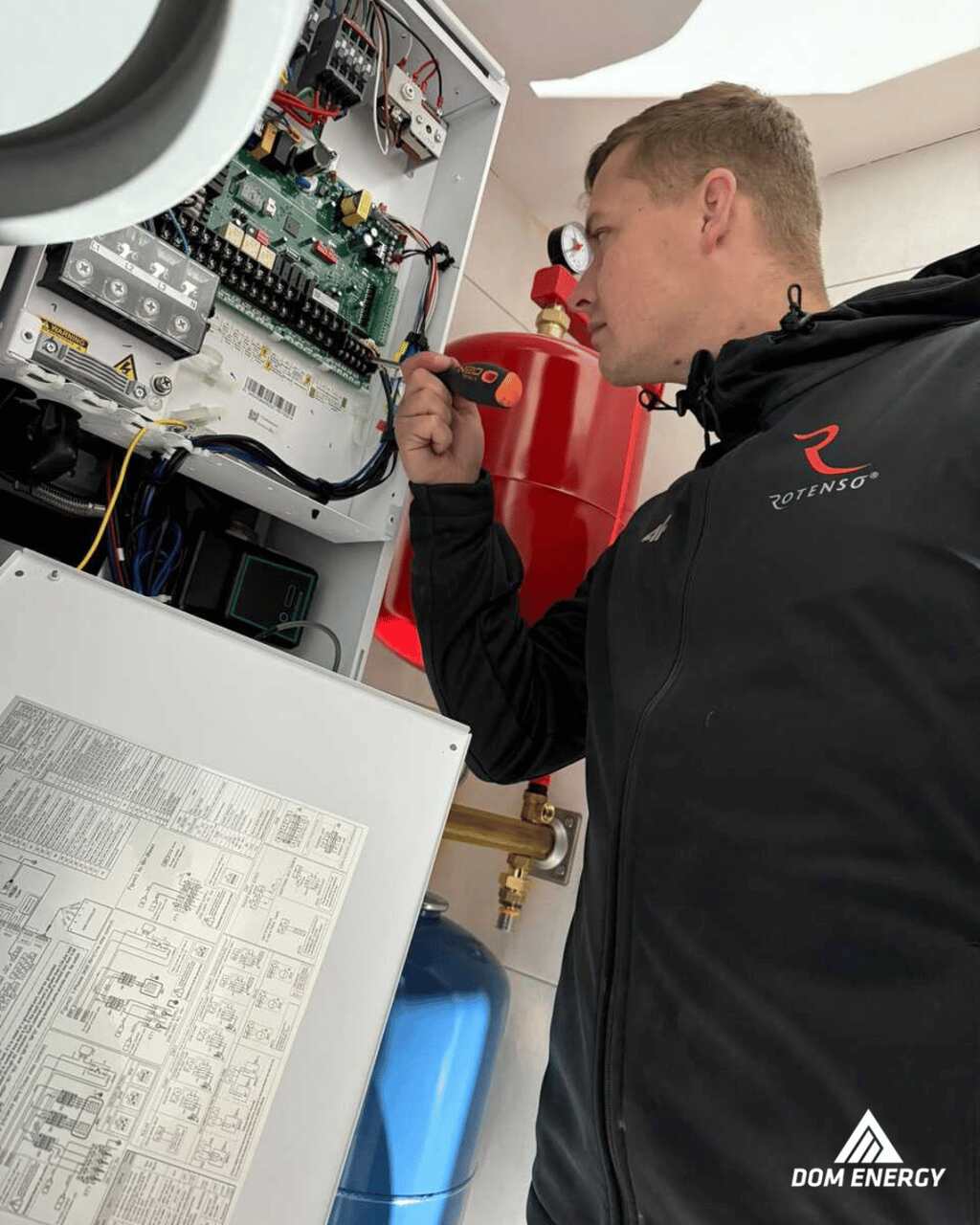 Instalator wykonuje podłączenia elektryczne wewnątrz jednostki pompy ciepła Rotenso Aquami 8 kW w Radomiu.